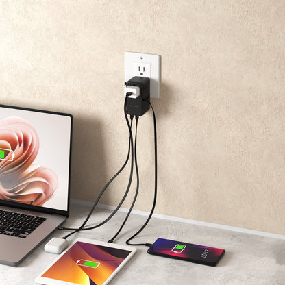 ReelCharge 100W Global Travel Charger plugged into a wall outlet charging a laptop, tablet and phone