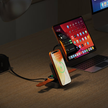 ReelCharge 5-in-1 Wireless Powerstation charging a phone on a desk at night next to a laptop
